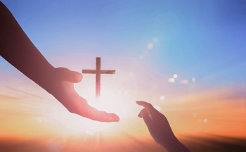 la main tendue a une autre main. Elle lui offre La Croix de Jésus-Christ