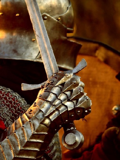 Une main en armure tenant une épée