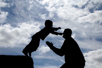 un enfant saute dans les bras de son père car il a confiance . Son père ne va pas le laisser tomber