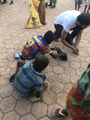Des enfants ramassent les graines de maïs et de mils tombées des sacs dans la commune de Boussé (Burkina-Faso)